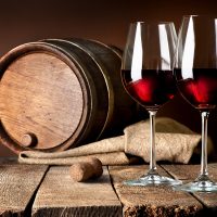 Barrel and wineglasses of red wine on a wooden table