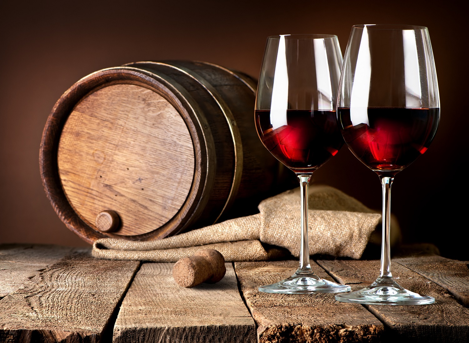 Barrel and wineglasses of red wine on a wooden table