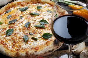 Whole pizza with a glass of wine